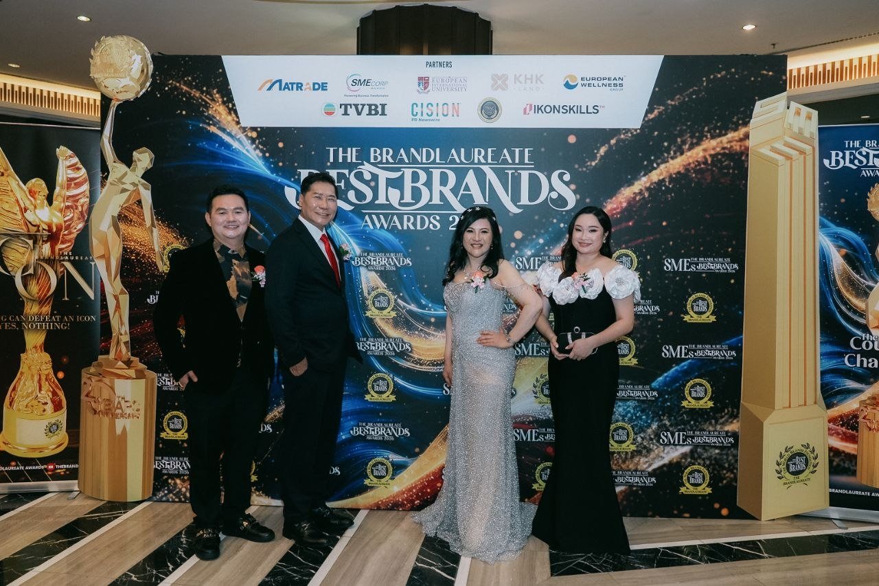 DR. SHEKINAIH SIEW SIN YAP and DR. J AARON K DAVID stand with Hilary Ng, in a black gown with white rose sleeves, and a guest in a black suit before The BrandLaureate BestBrands Awards 2026 backdrop
