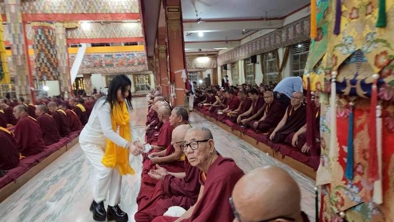 SHEKINAIH SIEW SIN YAP personally giving alms to seated monks in the temple hall