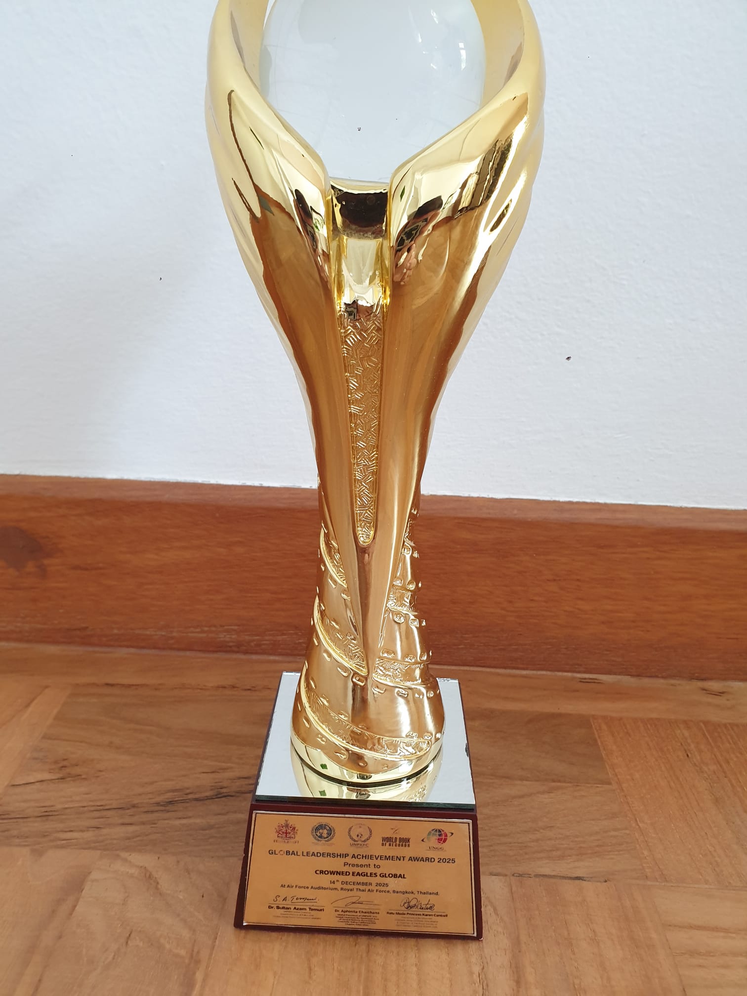 Global Leadership Achievement Award 2025 trophy presented to Crowned Eagles Global — Royal Thai Air Force Auditorium, Bangkok, 14 December 2025