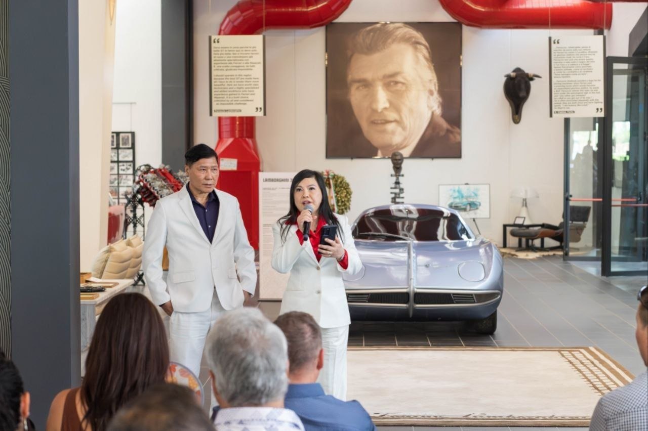 SHEKINAIH SIEW SIN YAP and J AARON K DAVID on the Lamborghini museum floor beside a silver Lamborghini 350 GTV, Italy, August 2026