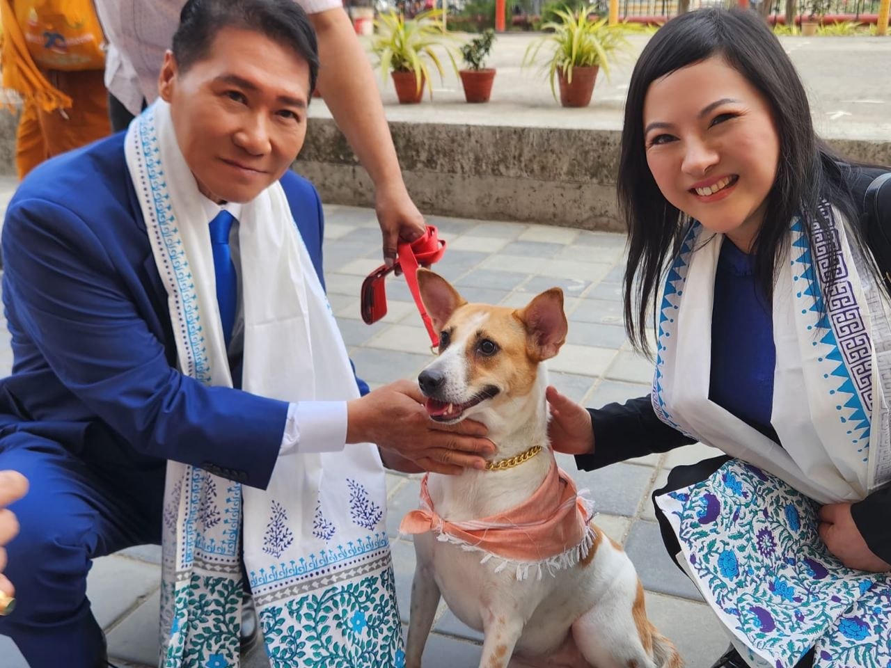 SHEKINAIH SIEW SIN YAP and J AARON K DAVID kneeling close beside Aloha, the rescued temple dog, sharing a gentle moment, Kolkata