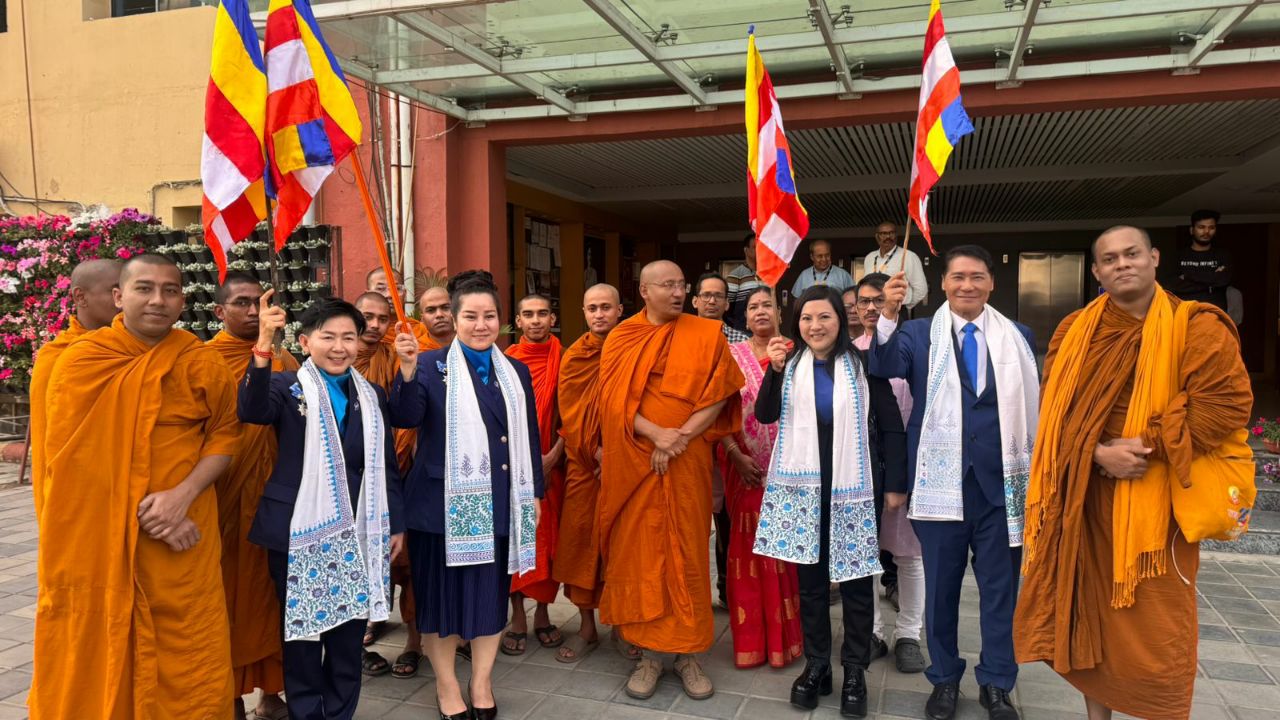 SHEKINAIH SIEW SIN YAP and J AARON K DAVID with senior Buddhist monastics holding international flags, Kolkata