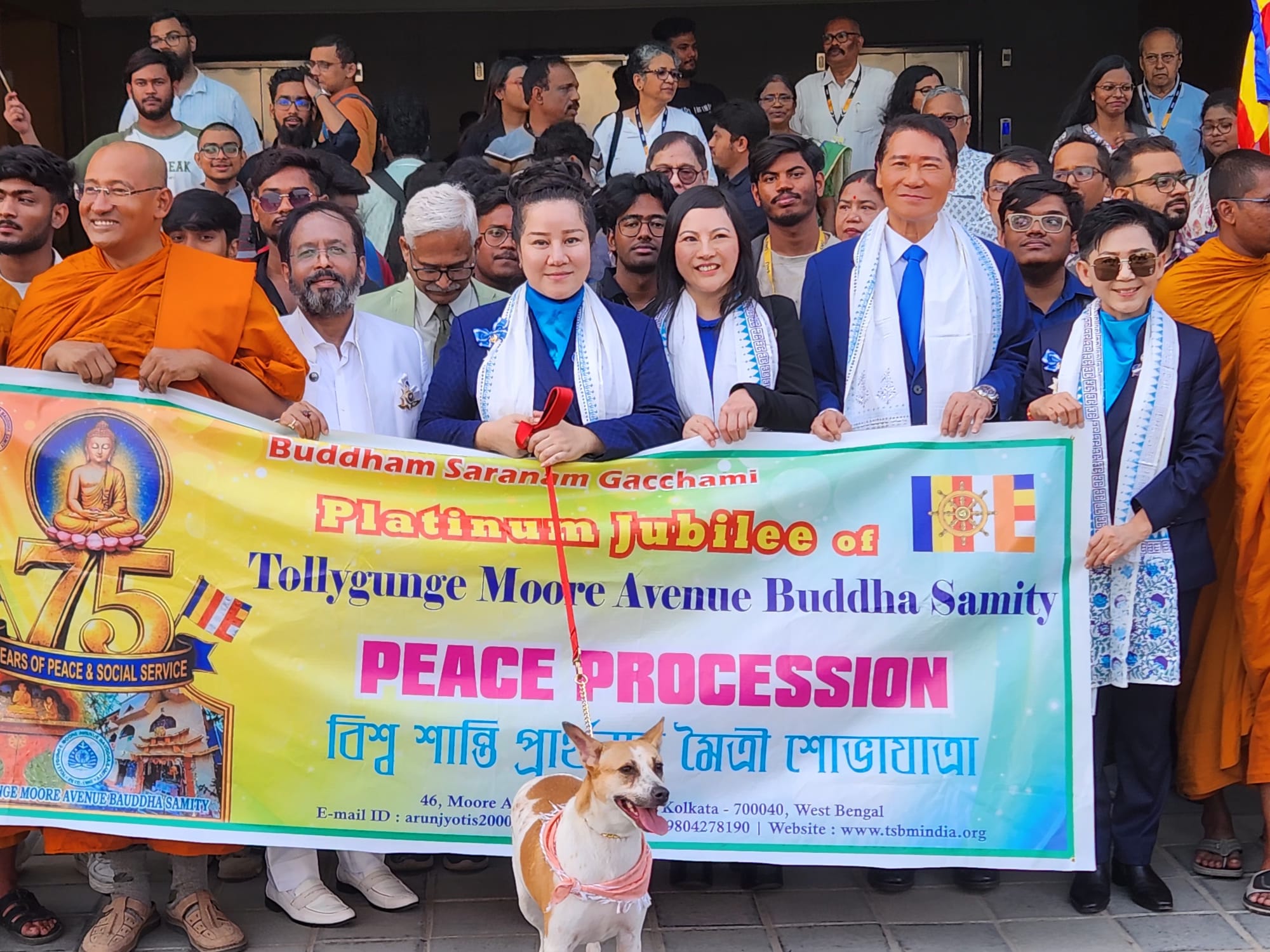 SHEKINAIH SIEW SIN YAP and J AARON K DAVID with monastic and lay leaders holding the 75 Years Peace Procession banner, with Aloha the dog seated before them, at the head of the Walking-PEACE march, Kolkata, 1 February 2026
